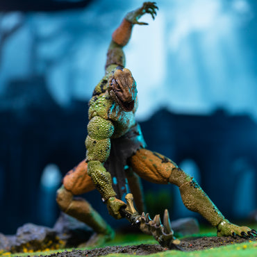 Green, yellow, and black Lemurian in loin cloth slashing forward with mandible club.