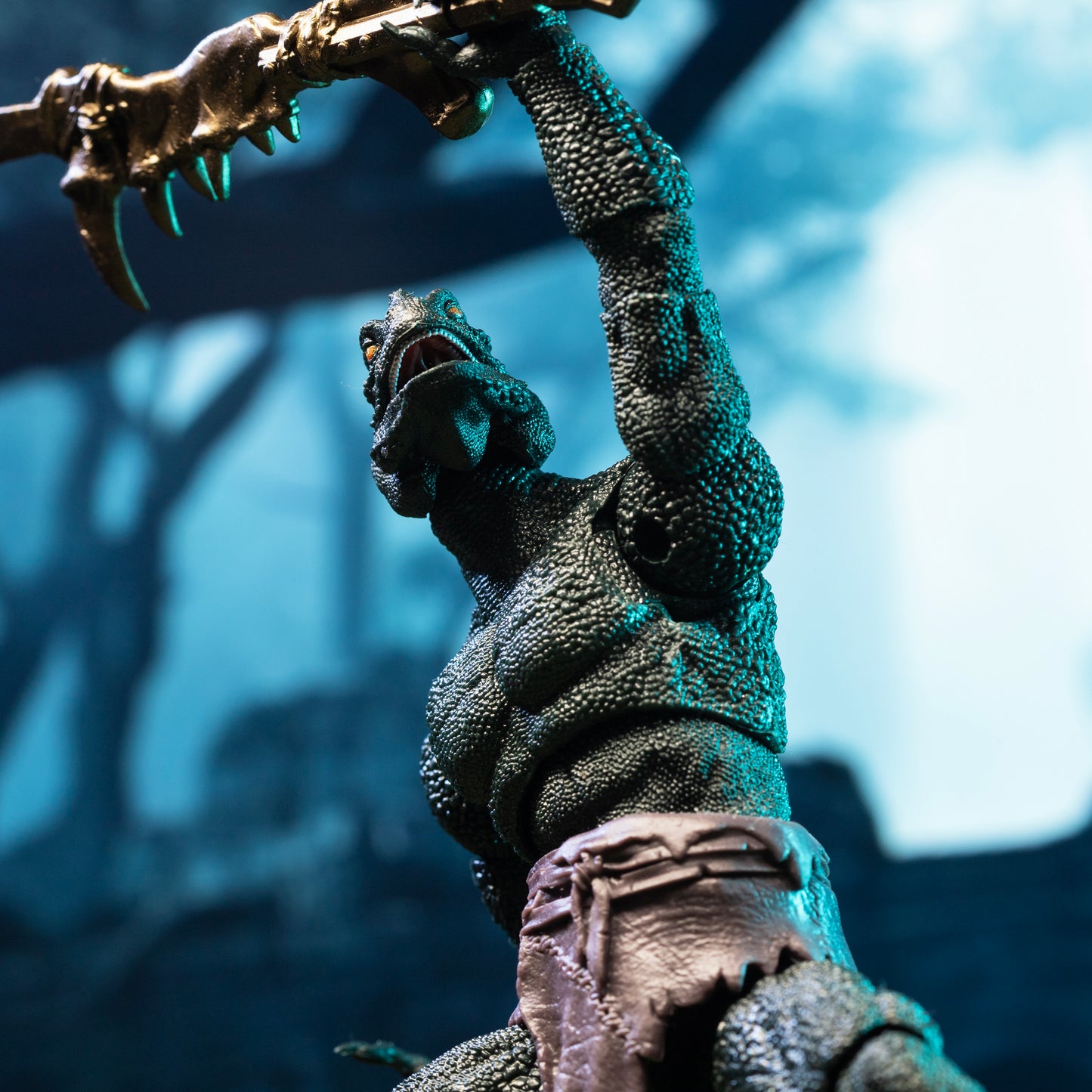 Close up from waist height of green Lemurian in loin cloth holding mandible club above head.