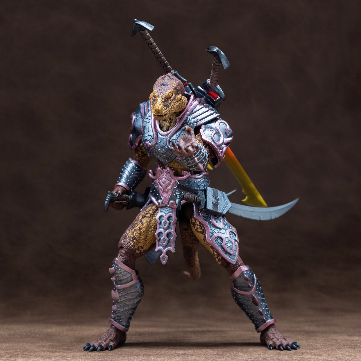 Fully armored brown and yellow Lemurian gesturing forward with his left and hand and holding a sword sheathed at his hip with his right hand, with two additional swords sheathed on back.