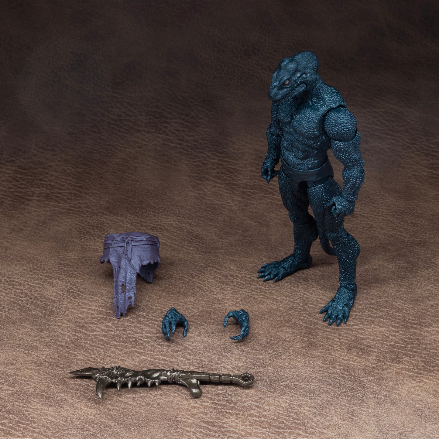 Load out image. Green Lemurian standing at attention beside all included accessories: loin cloth, alternate gripping and gesturing hands, and mandible club.